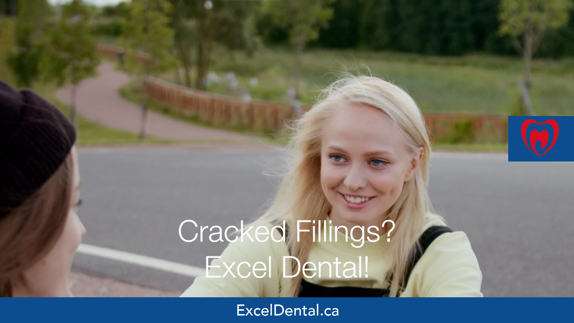 Smiling young woman outdoors with another person, overlaid with Excel Dental cracked fillings promotional text.
