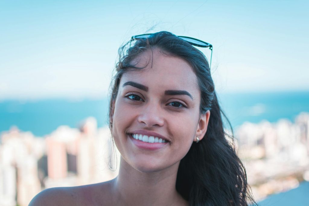 Smiling woman showing teeth in a front-facing outdoor portrait